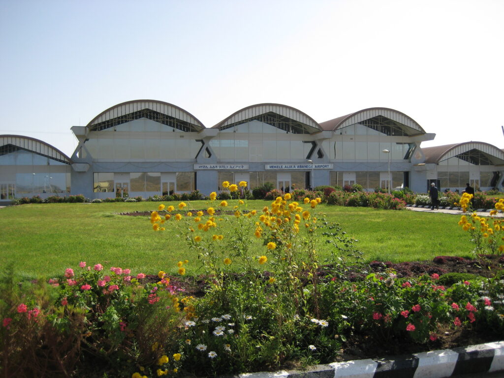 Mekelle Airport terminal behind a landscaped lawn and flower beds.
