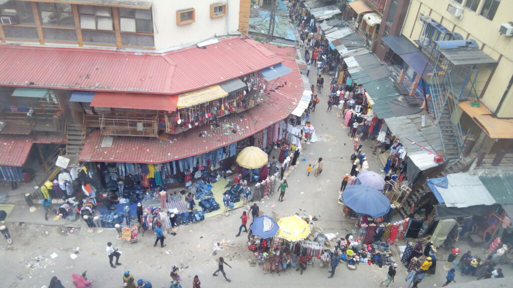 An elevated view of stalls, umbrellas and people at Balogun Market on Lagos Island.