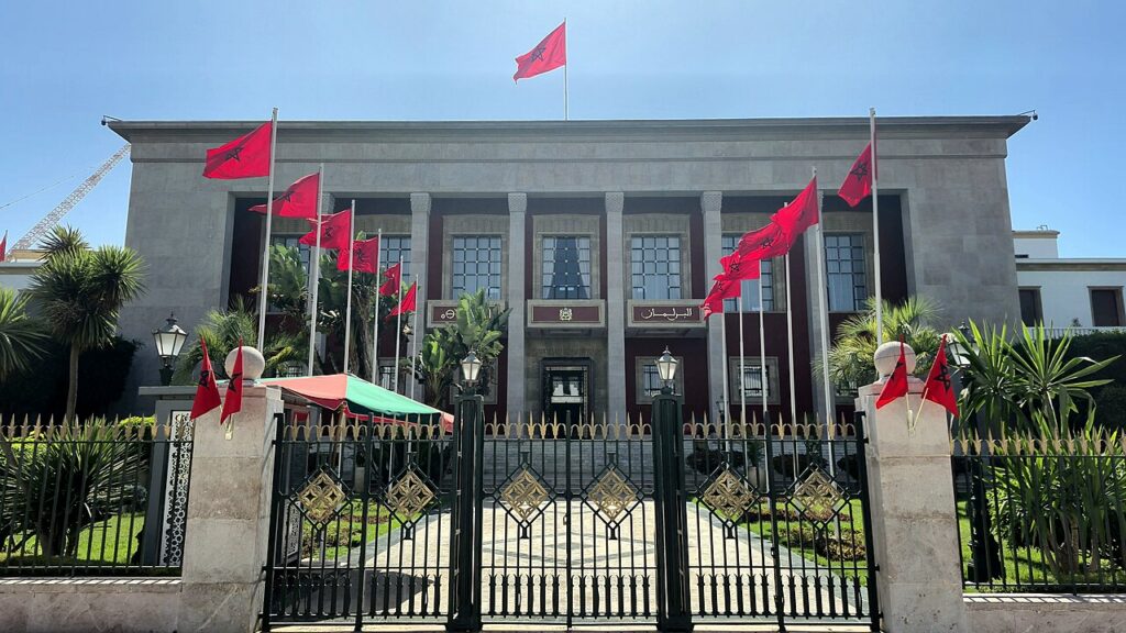 Morocco’s parliament building in Rabat, with red flags and a gated entrance.